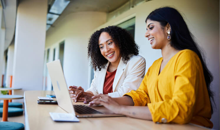 two women working on a laptop together